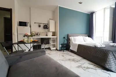a bedroom with a bed and a table and a kitchen at Appartamento Ottanio- Quattro Canti 200 mt in Palermo