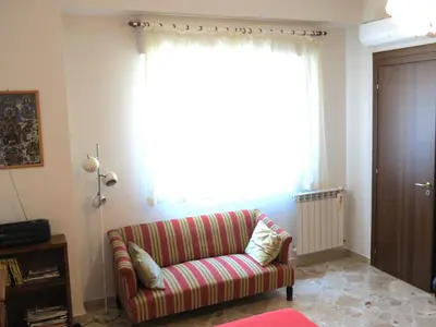 a living room with a couch and a large window at Appartamento Blu in Palermo