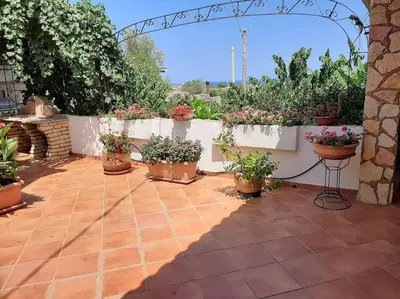 a patio with potted plants on a white fence at Casa Vacanze Anthea Carini in Carini
