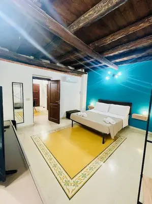 a living room with a bed and a blue wall at Biscottari's home in Palermo