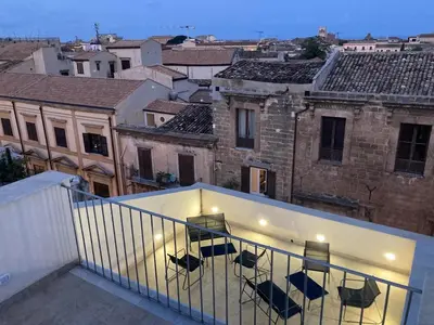 a balcony with chairs and a table on a building at B&B Garibaldi in Palermo