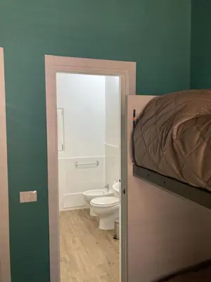 a bathroom with a bed and a toilet in a room at B&B Garibaldi in Palermo