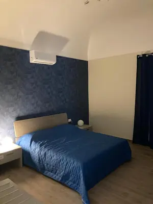 a bedroom with a bed with a blue bedspread at B&B Garibaldi in Palermo