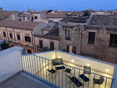 a balcony with chairs and a view of a city at B&B Garibaldi in Palermo