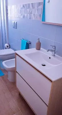 a white bathroom with a sink and a toilet at Casa Nenè in Trabia
