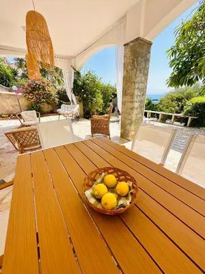 a bowl of lemons sitting on a wooden table at Rosa's House in Santa Flavia