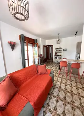 a living room with a green couch and red pillows at Rosa's House in Santa Flavia