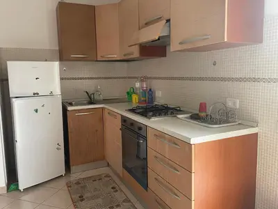 a kitchen with wooden cabinets and a white refrigerator at Villetta 200mt mare e piscina in Campofelice di Roccella