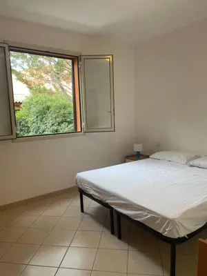 a bedroom with a bed and a window at Villetta 200mt mare e piscina in Campofelice di Roccella