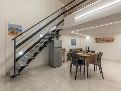 a dining room with a table and a staircase at La Casetta di Mari by Holiday World in Villabate