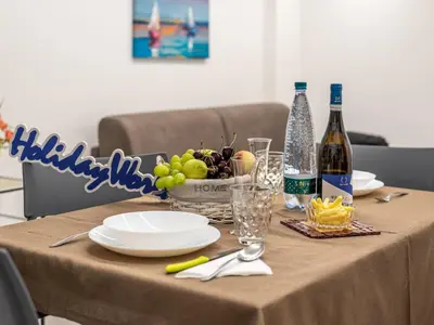 a table with a bottle of wine and a plate of fruit at La Casetta di Mari by Holiday World in Villabate
