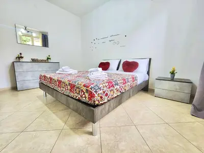 a bedroom with a bed with red pillows on it at Bay View Wi-Fi-Vista Mare-Free Parking in Carini