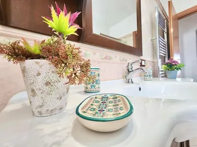 a bathroom sink with a vase with flowers on it at Bay View Wi-Fi-Vista Mare-Free Parking in Carini