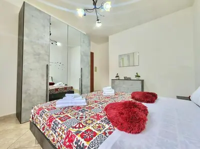 a bedroom with a large bed with red pillows on it at Bay View Wi-Fi-Vista Mare-Free Parking in Carini