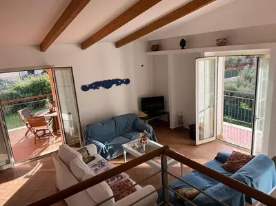 a living room with couches and a television and a balcony at traversa 8, aeroporto in Cinisi
