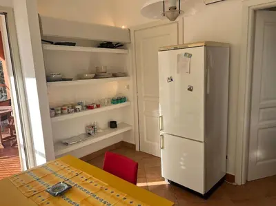 a kitchen with a table and a white refrigerator at traversa 8, aeroporto in Cinisi