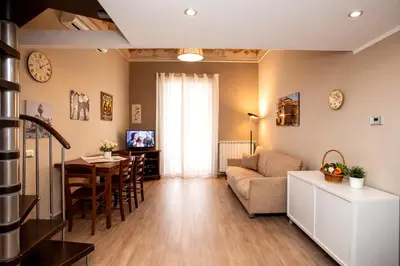 a living room with a couch and a flat screen tv at Le Quattro Stagioni - Apartments in Palermo