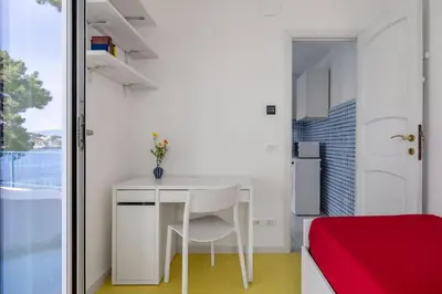 a small white table in a room with a bed at Terrazza sul mare in Santa Flavia
