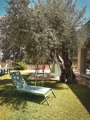 a hammock sitting in the grass next to a tree at Dimora Harmonia in Carini