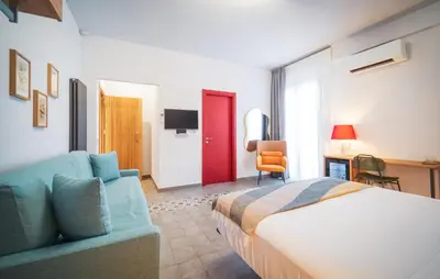 a bedroom with a bed and a couch and a chair at Dimora Harmonia in Carini