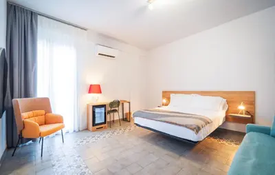 a bedroom with a bed and a chair and a couch at Dimora Harmonia in Carini