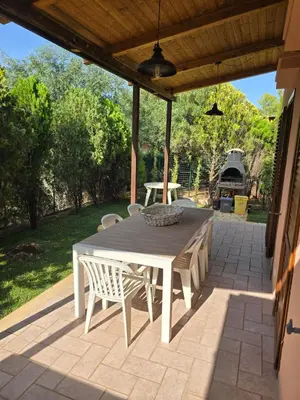 a patio with a table and chairs on a patio at Villetta Viola in San Vito lo Capo