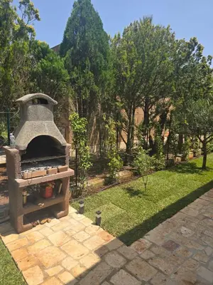 a stone oven in a garden with trees in the background at Villetta Viola in San Vito lo Capo