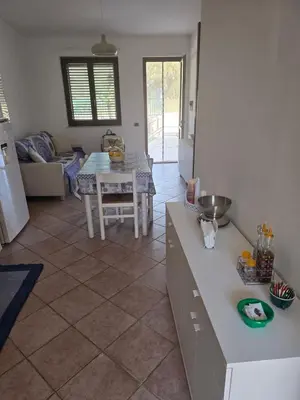 a kitchen and living room with a table and a tableablish at Villetta Viola in San Vito lo Capo