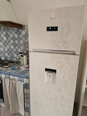 a refrigerator with a clock on it in a kitchen at Villetta Viola in San Vito lo Capo