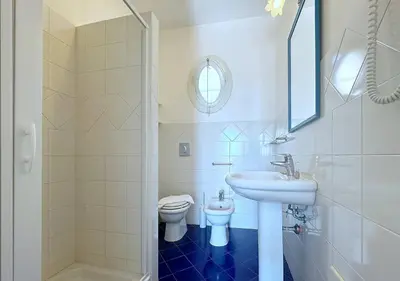 a white bathroom with a sink and a toilet at Solemar Sicilia - Palazzo Eos e Aura in Porticello