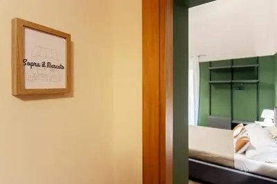 a room with a bed and a mirror with a picture at Prospettiva Ballarò - Sopra il mercato in Palermo