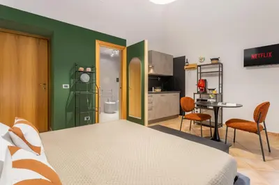 a bedroom with a large bed and a kitchen at Prospettiva Ballarò - Sopra il mercato in Palermo