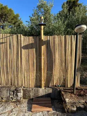 a wooden fence with a light next to a pole at Cocciu D'amuri Home - Scopello in Scopello