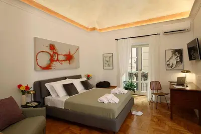 a bedroom with a large bed and a couch at Porto Felice Home Palermo in Palermo