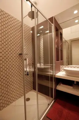 a bathroom with a glass shower and a sink at Porto Felice Home Palermo in Palermo