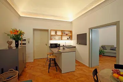 a room with a kitchen and a living room with a table at Porto Felice Home Palermo in Palermo