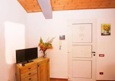 a room with a television on a dresser and a door at Villa Cicas sul mare in Campofelice di Roccella