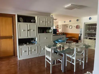 a kitchen with white cabinets and a table and chairs at La Terrazza del Sole in Lido di Mondello