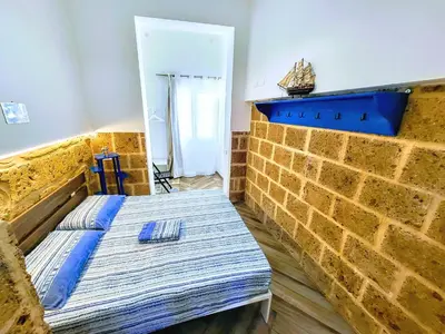 a bedroom with a bed and a brick wall at Seafront House Gabbiano Blu in Santa Flavia
