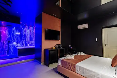 a hotel room with a bed and a tv at SUPREME Suite&Spa in Palermo