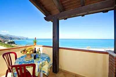 a table with a bowl of fruit and a view of the ocean at Blunda Holiday Home in Castellammare del Golfo
