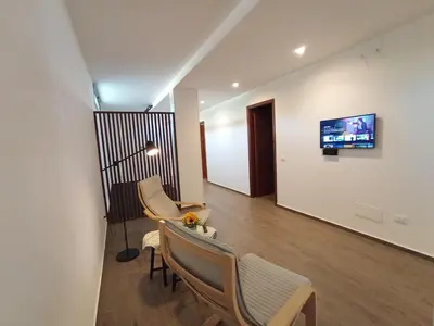 a living room with two chairs and a tv on a wall at Casa di Lele in Carini