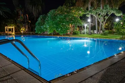 a large blue swimming pool at night at Villa Megna - Green Paradise B&B in Sferracavallo