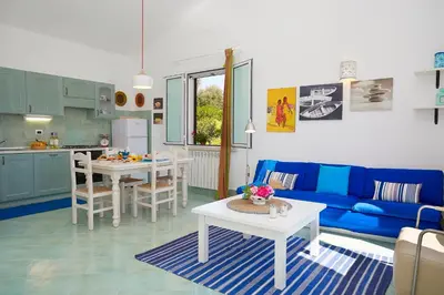 a living room with a blue couch and a table at Villa Sirena - Scopello-Villas in Scopello