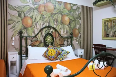 a bedroom with an orange bed with a painting on the wall at Orange Lemon Garden Palermo in Palermo