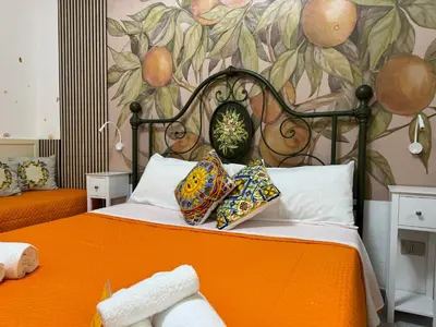 a bedroom with an orange bed with a painting on the wall at Orange Lemon Garden Palermo in Palermo