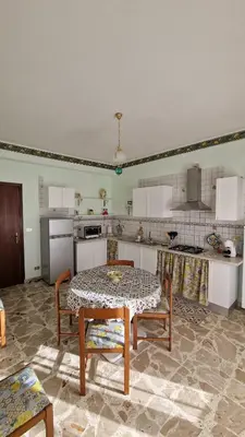 a living room with a table and a kitchen at Casa vacanza-Il Sole di Sicilia in Vita