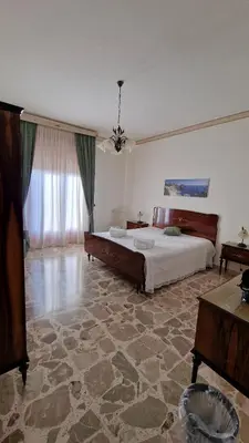 a large bedroom with a bed and a table at Casa vacanza-Il Sole di Sicilia in Vita