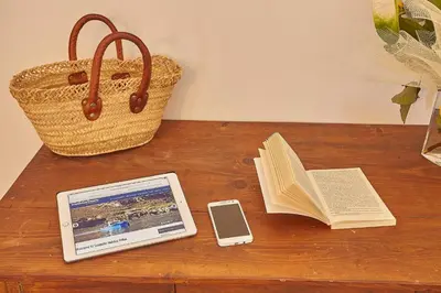 a table with a tablet and a book and a cell phone at Villa del Poggio in Scopello