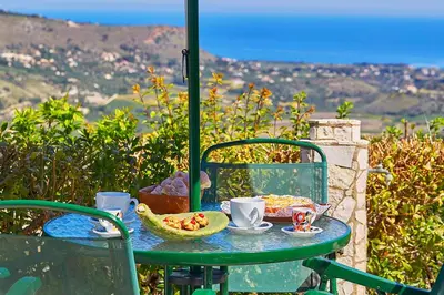 a table with a plate of food on it at Villa del Poggio in Scopello